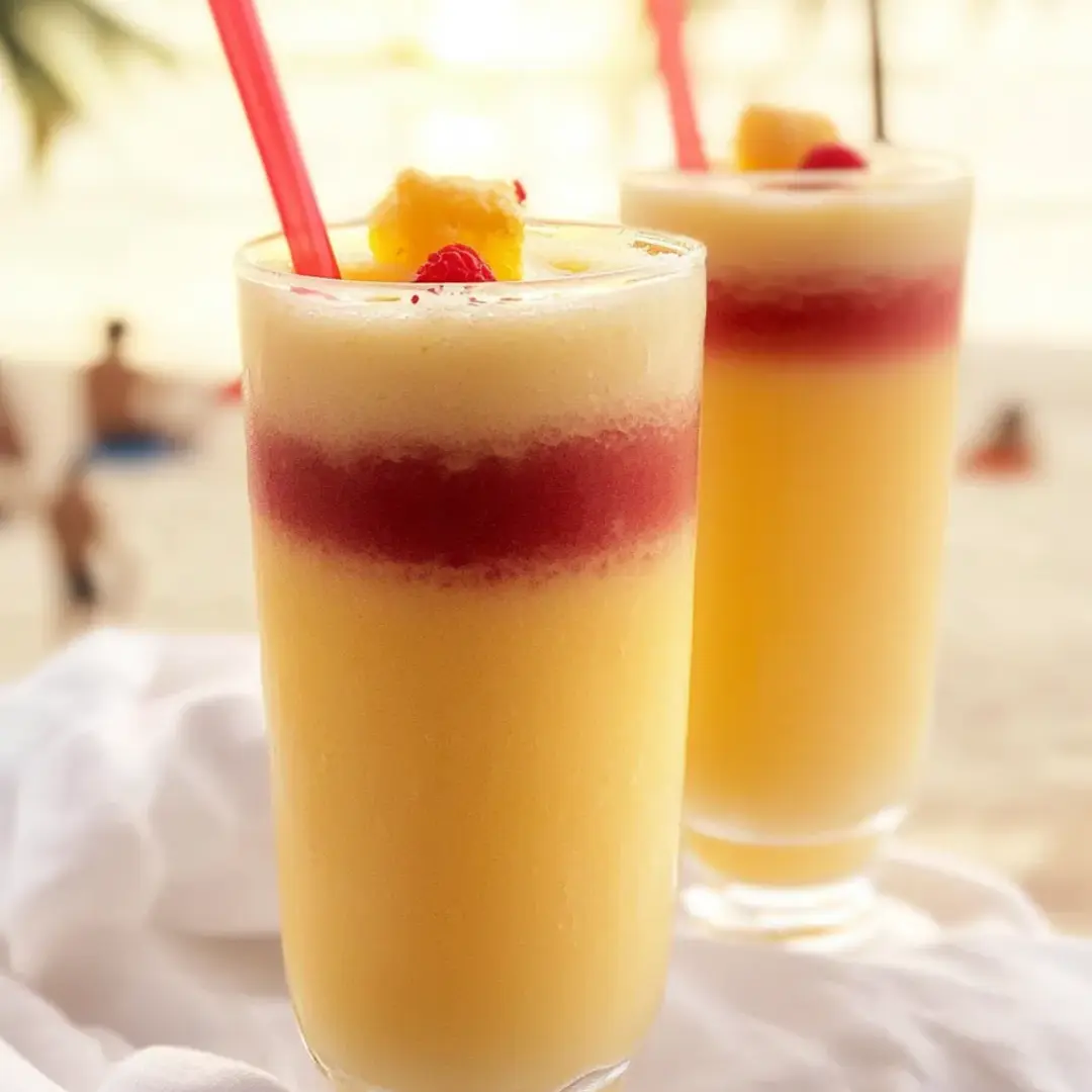 Two glasses of orange juice with straws.
