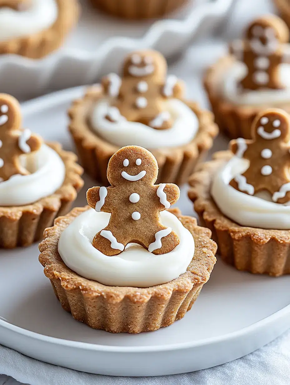 A plate of mini gingerbread cookies topped with cream frosting, featuring small gingerbread men decorations.