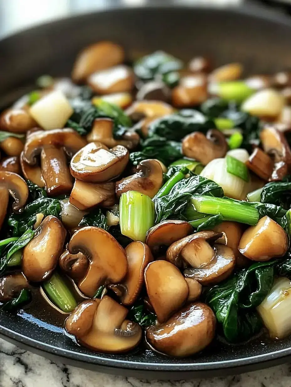 A close-up image of sautéed mushrooms and green vegetables in a black skillet.