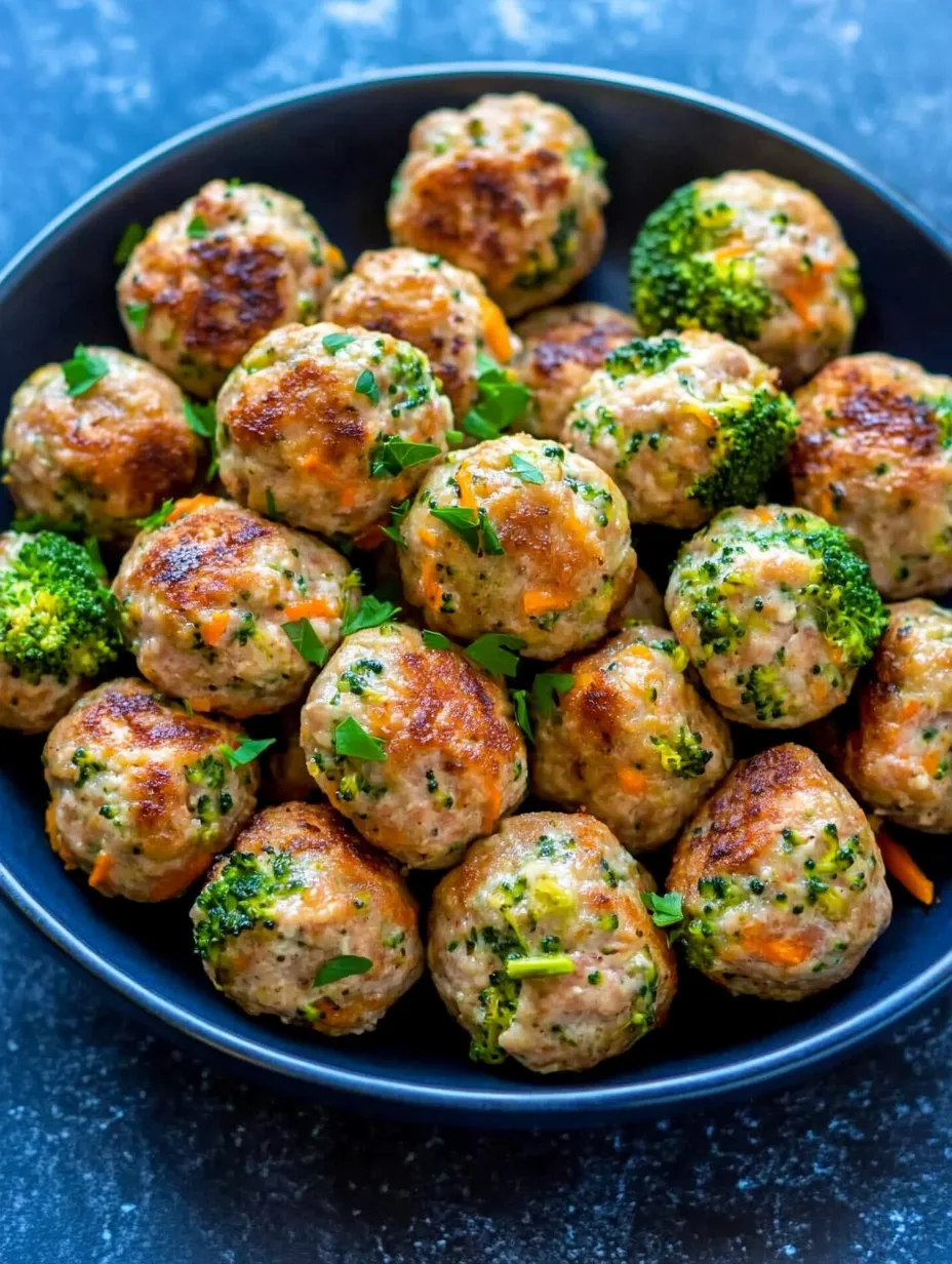 A bowl of meatballs with broccoli on top.