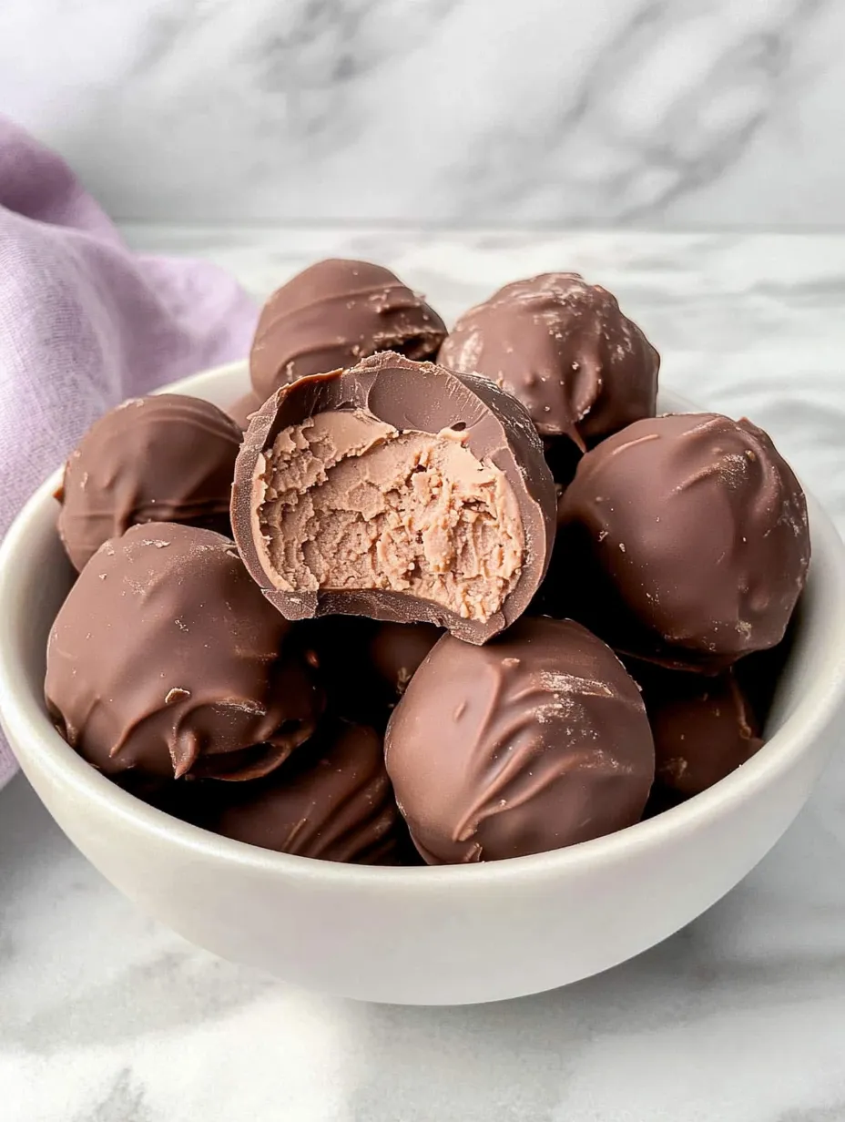 A bowl of chocolate balls with a chocolate ball in the middle.