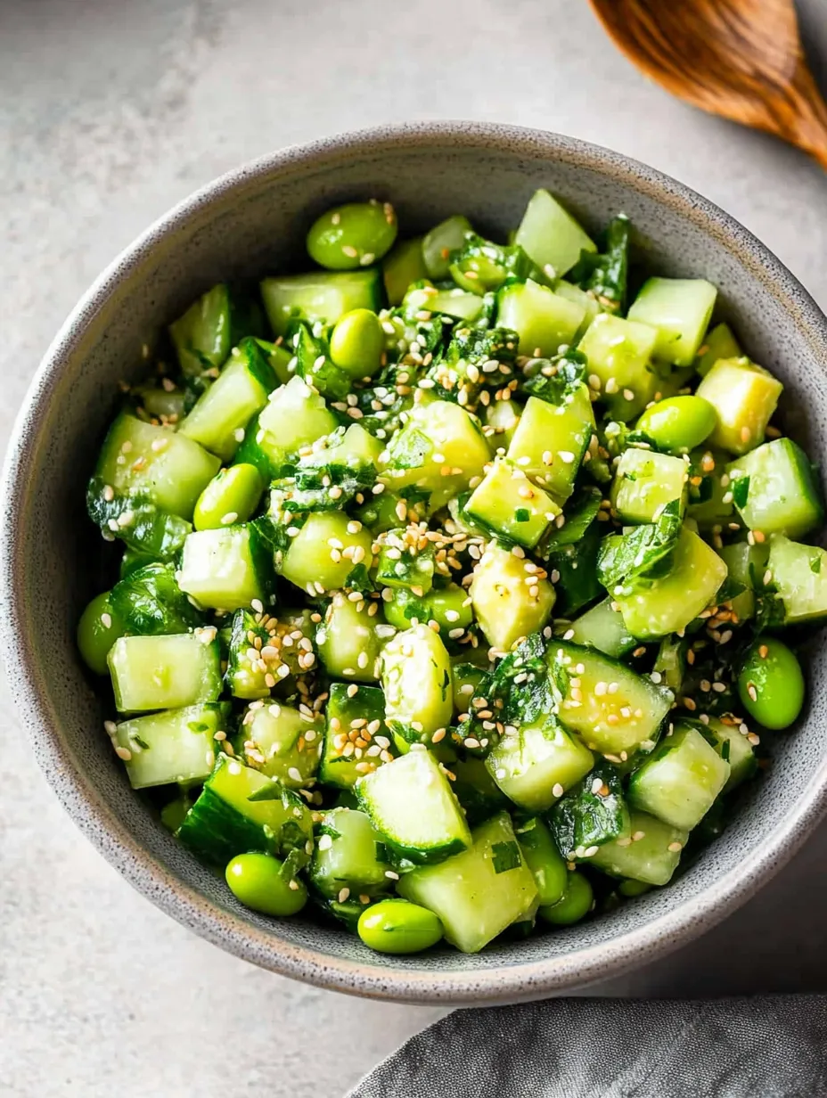 A bowl of vegetables, including cucumbers, is filled with a mixture of rice and seasonings.