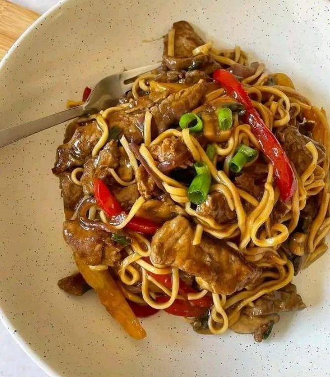 A plate of food with noodles and meat.