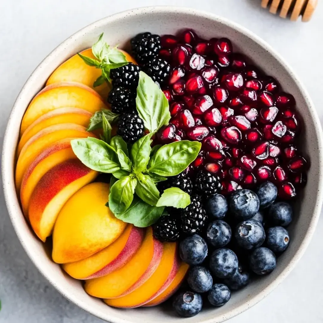 A bowl of fruit with blueberries, raspberries, and blackberries.