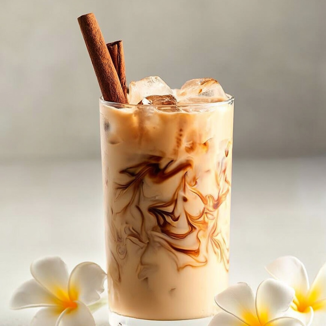 A glass of coffee with cinnamon on top.