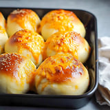 A pan of bread with cheese on top.