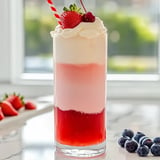 A glass of red and white drink with a strawberry on top.