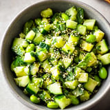 A bowl of vegetables, including cucumbers, is filled with a mixture of rice and seasonings.