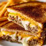 A sandwich with cheese and meat on a white plate.