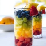 A glass of fruit juice with strawberries and blueberries.