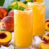 Two glasses of peach juice with mint garnish.