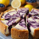 A slice of pie with blueberries and lemon.