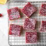A tray of red jello squares with powdered sugar on top.