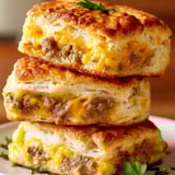 Three stacked biscuits with cheese.