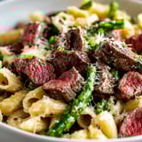 Pasta bowl packed with steak and asparagus.
