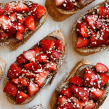 A close up of a strawberry and chocolate covered croissant.