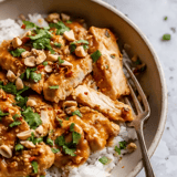 A bowl of food with chicken and rice.
