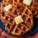 Two waffles with butter on top.
