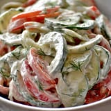 A bowl of vegetables with a white sauce.