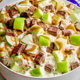A bowl of fruit with chocolate sauce.