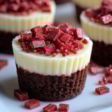 A cupcake with red jello and chocolate frosting.
