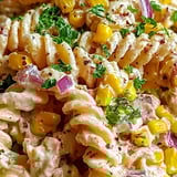 A bowl of pasta with corn and onions.